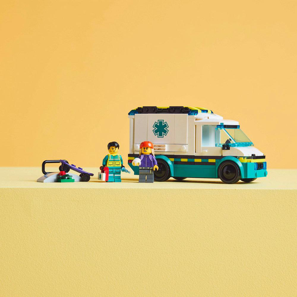 Lego-Set: Krankenwagen, Figuren, Trage. Gelber Boden, gelber Hintergrund.