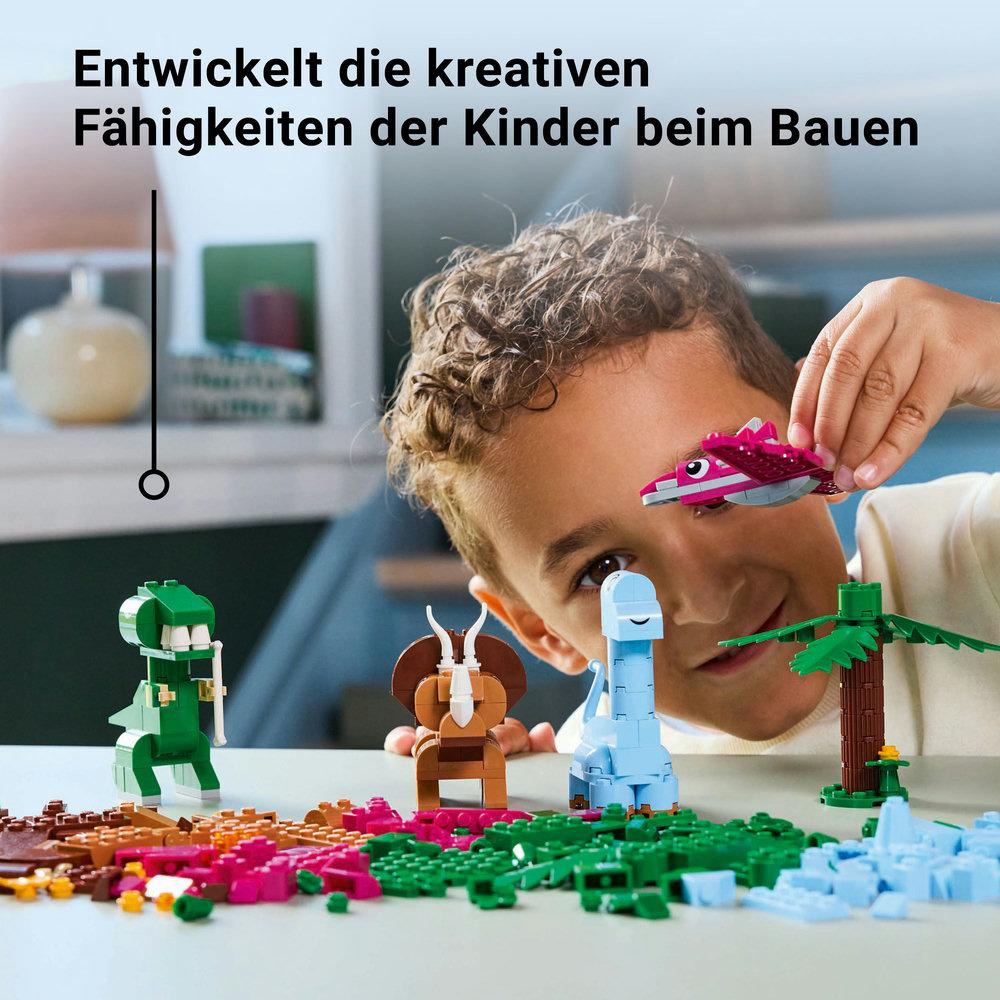 Ein Junge, der mit LEGO-Figuren spielt, mit einem rosa Flugzeug und mehreren anderen Figuren.