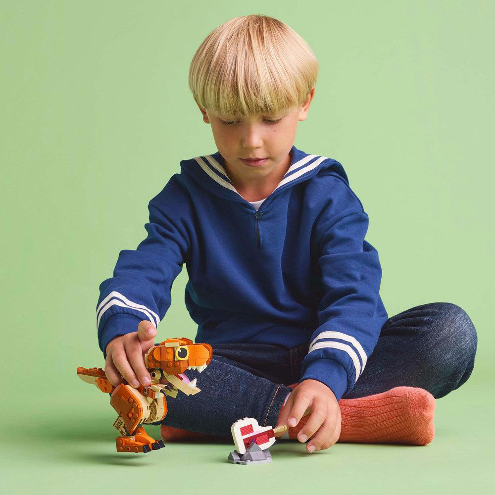 Ein Kind spielt mit einem Lego-Dinosaurier-Spielzeug.