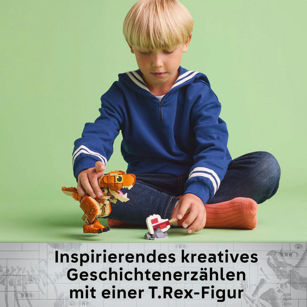 Ein Kind spielt mit einer Lego T-Rex-Figur und einer kleinen weiß-roten Struktur.