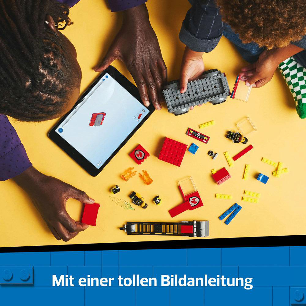 Zwei Personen bauen Lego-Teile auf gelber Oberfläche zusammen, verwenden Tablet mit Anleitung.