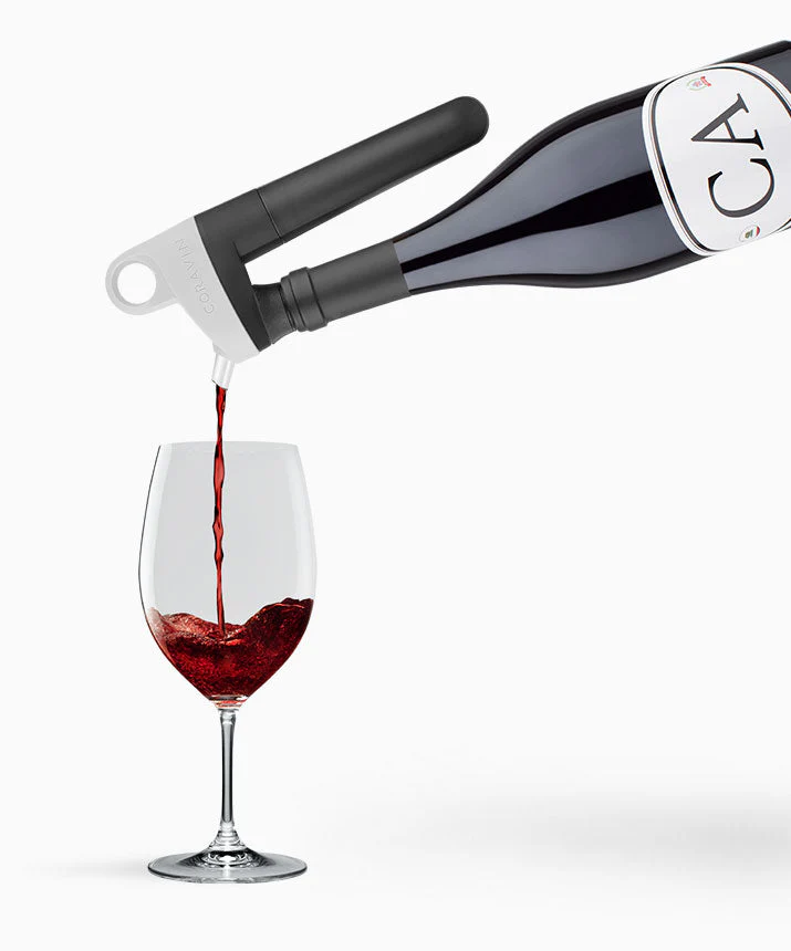 Wein wird aus einem schwarzen und weißen Coravin-Wein-System in ein Glas gegossen.
