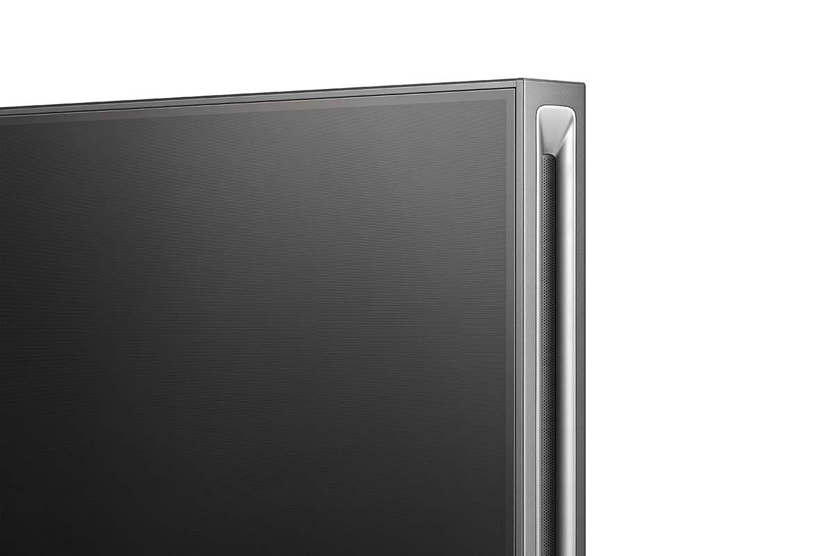 Zbliżenie rogu ekranu telewizora, pokazujące ramkę i konstrukcję przypominającą otwory wentylacyjne z boku.