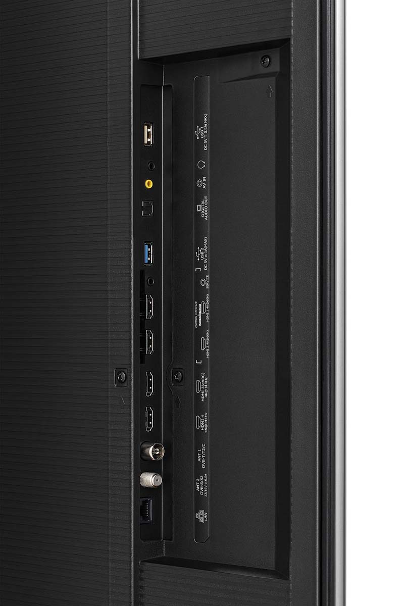 Tył telewizora z portami: USB, HDMI, antena, wyjście audio. Czarna tekstura po lewej.