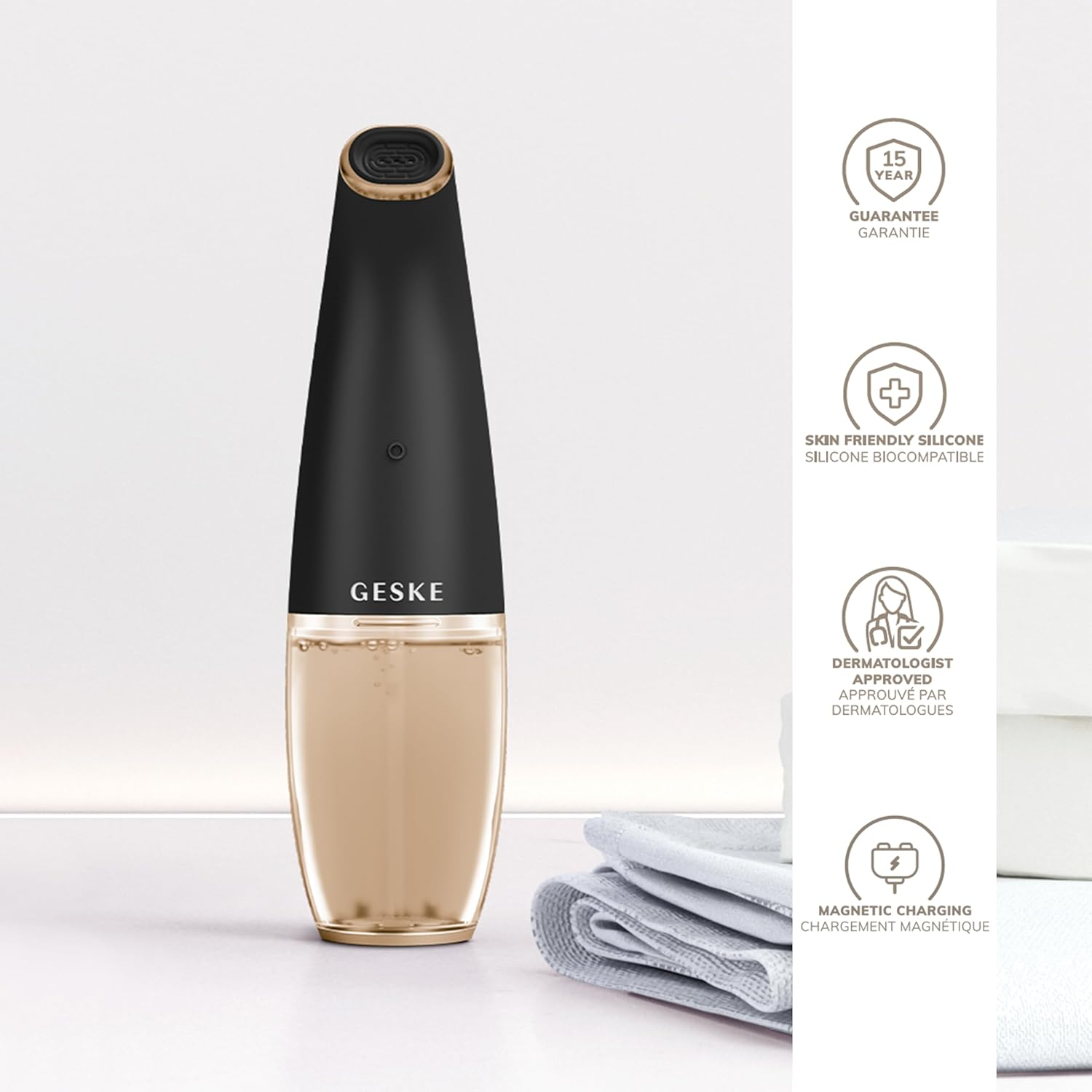 Dispositivo de limpieza facial Geske. Diseño negro y dorado, con un frasco de sérum y toalla.