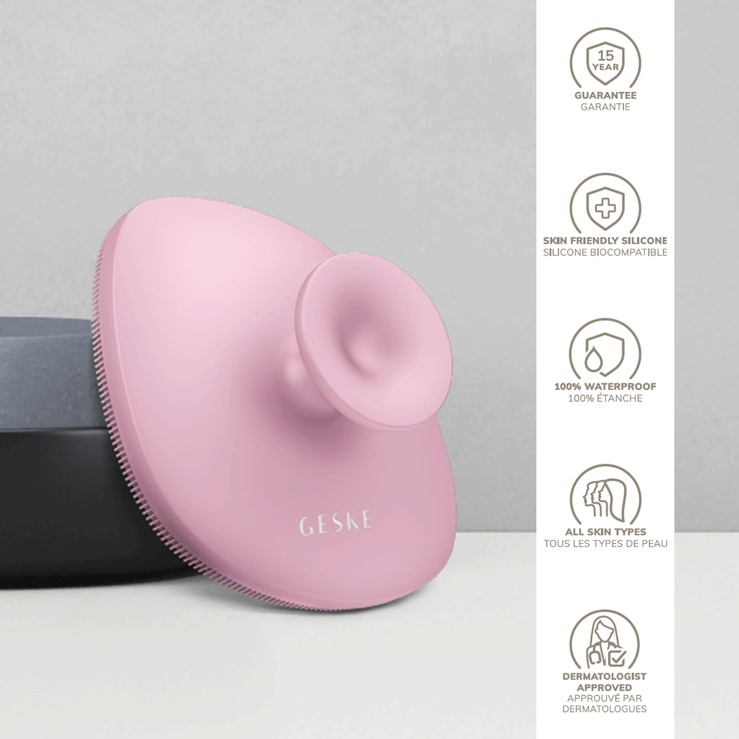Limpiador facial rosa con mango y cerdas. Hay iconos blancos a la derecha.