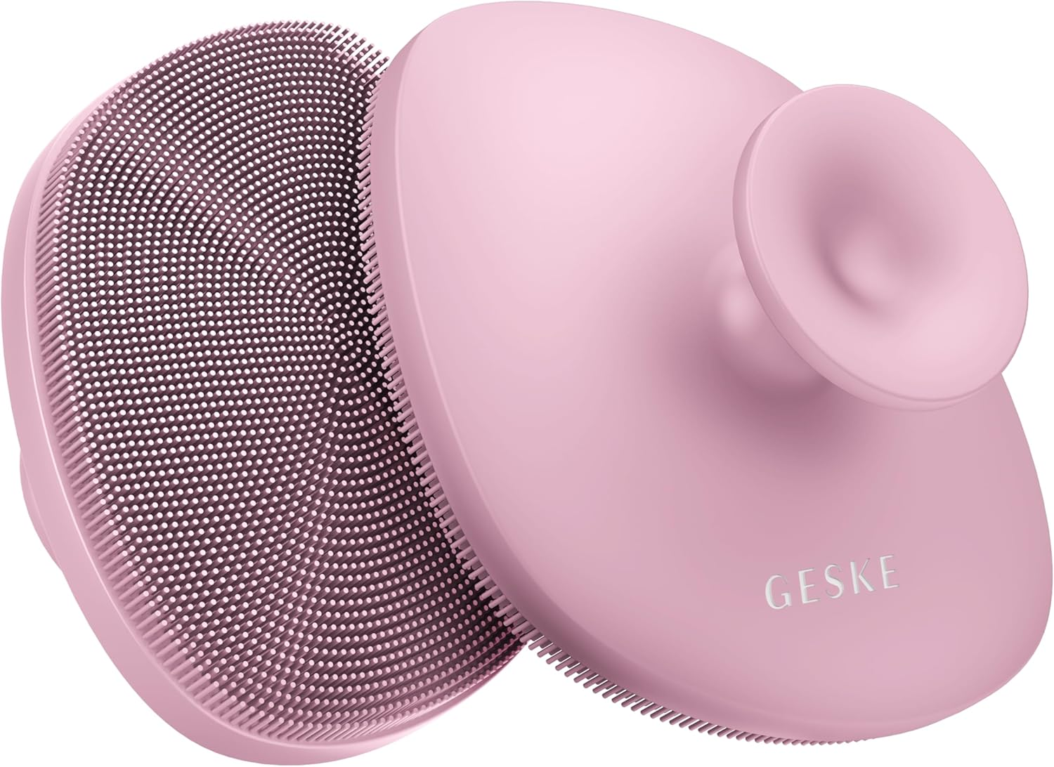 Un cepillo de limpieza facial rosa con superficie texturizada y mango.