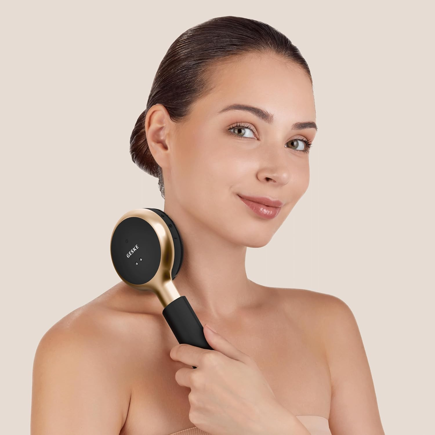 Una mujer usando un dispositivo de masaje en su cuello. El dispositivo es negro y dorado.