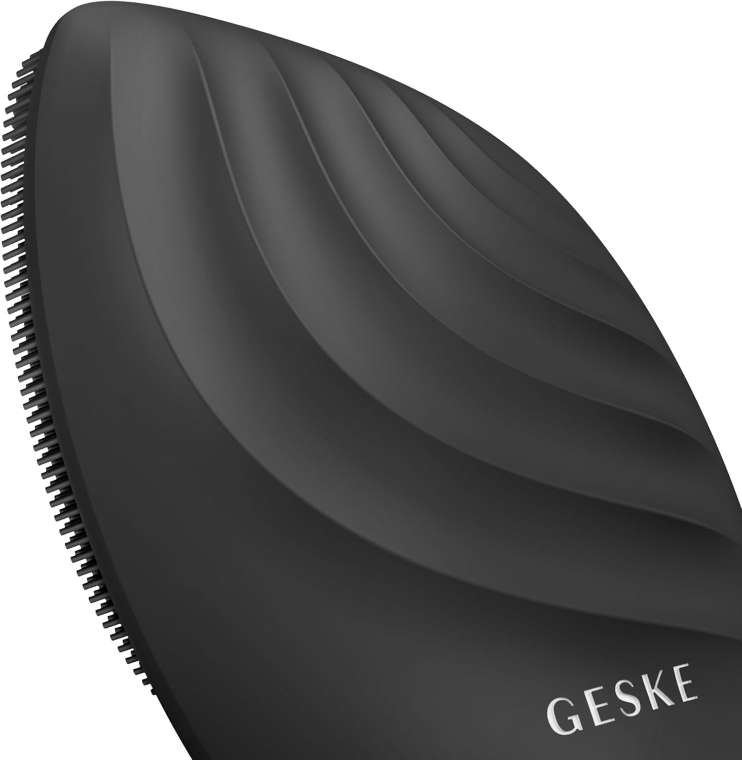 Primer plano de un limpiador facial Geske negro. Diseño texturizado y curvado. Logotipo Geske visible.