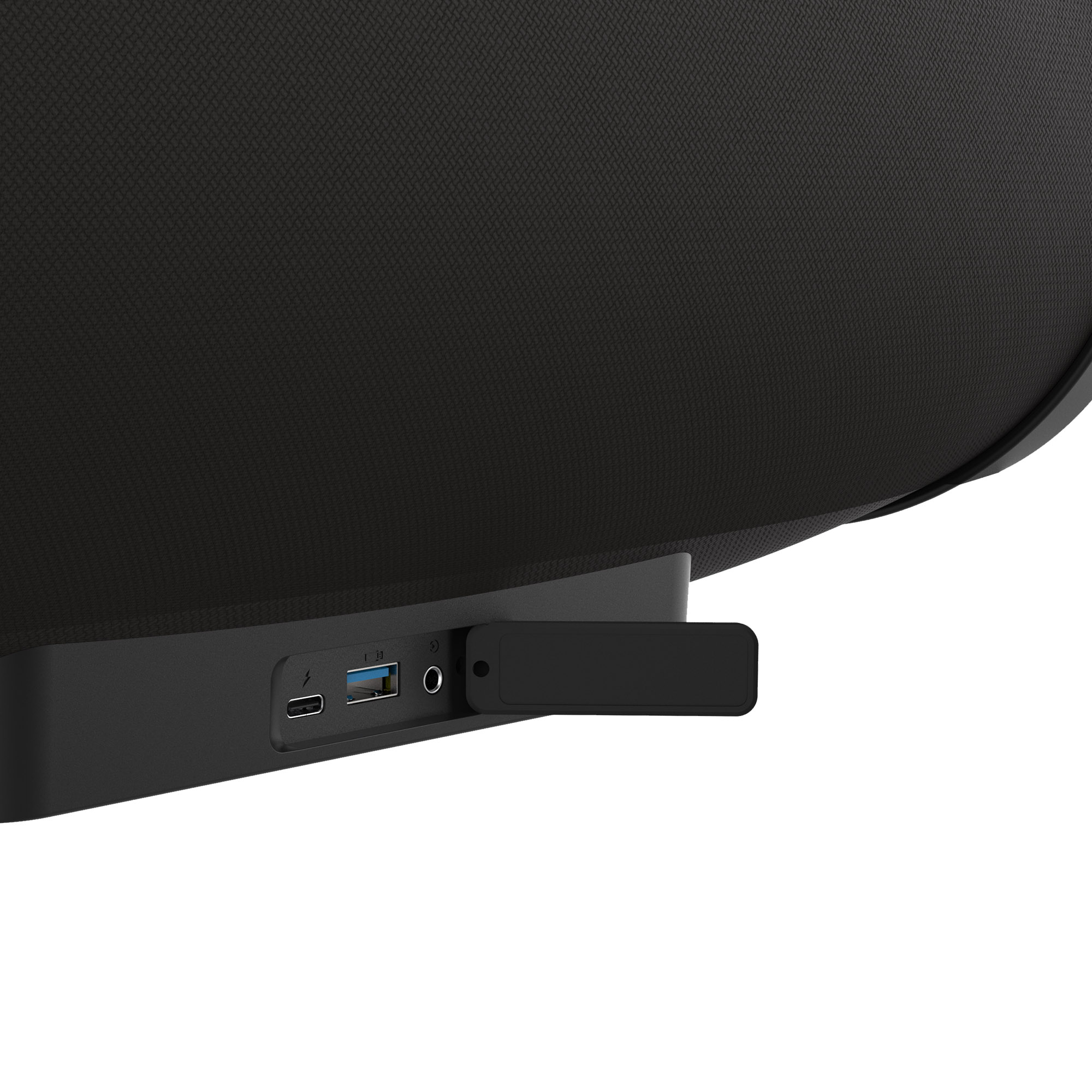 Altavoz negro con puertos. Puertos USB, alimentación y audio visibles, con una pequeña puerta abierta.