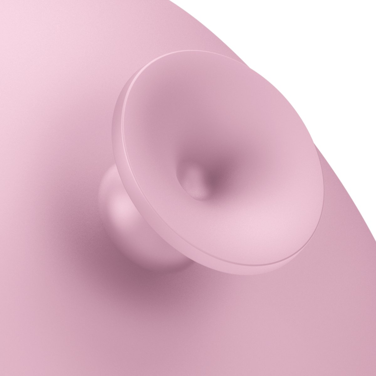 Dispositivo rosa con una parte superior cóncava redonda y blanca. El dispositivo está sobre una superficie rosa.