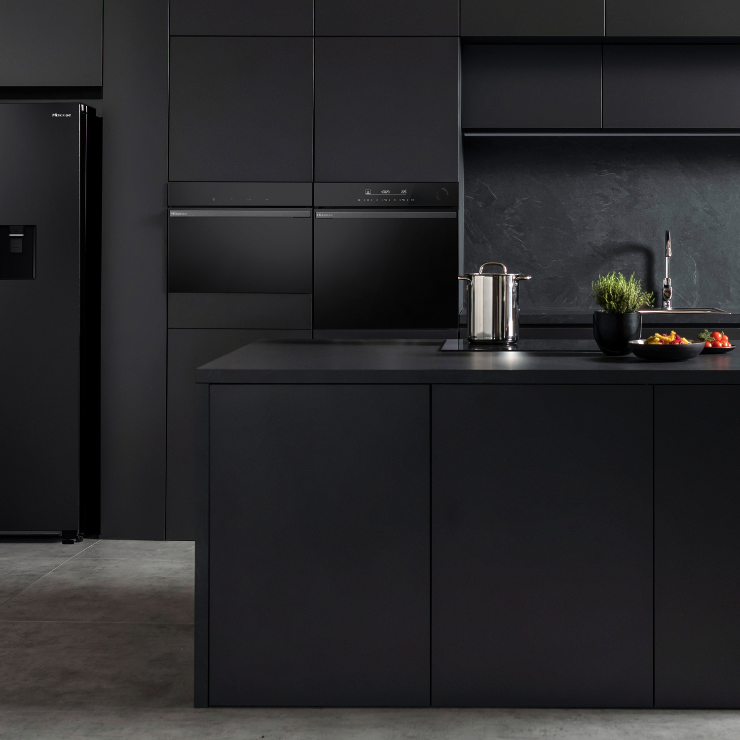 Cocina negra moderna con electrodomésticos empotrados, nevera e isla.