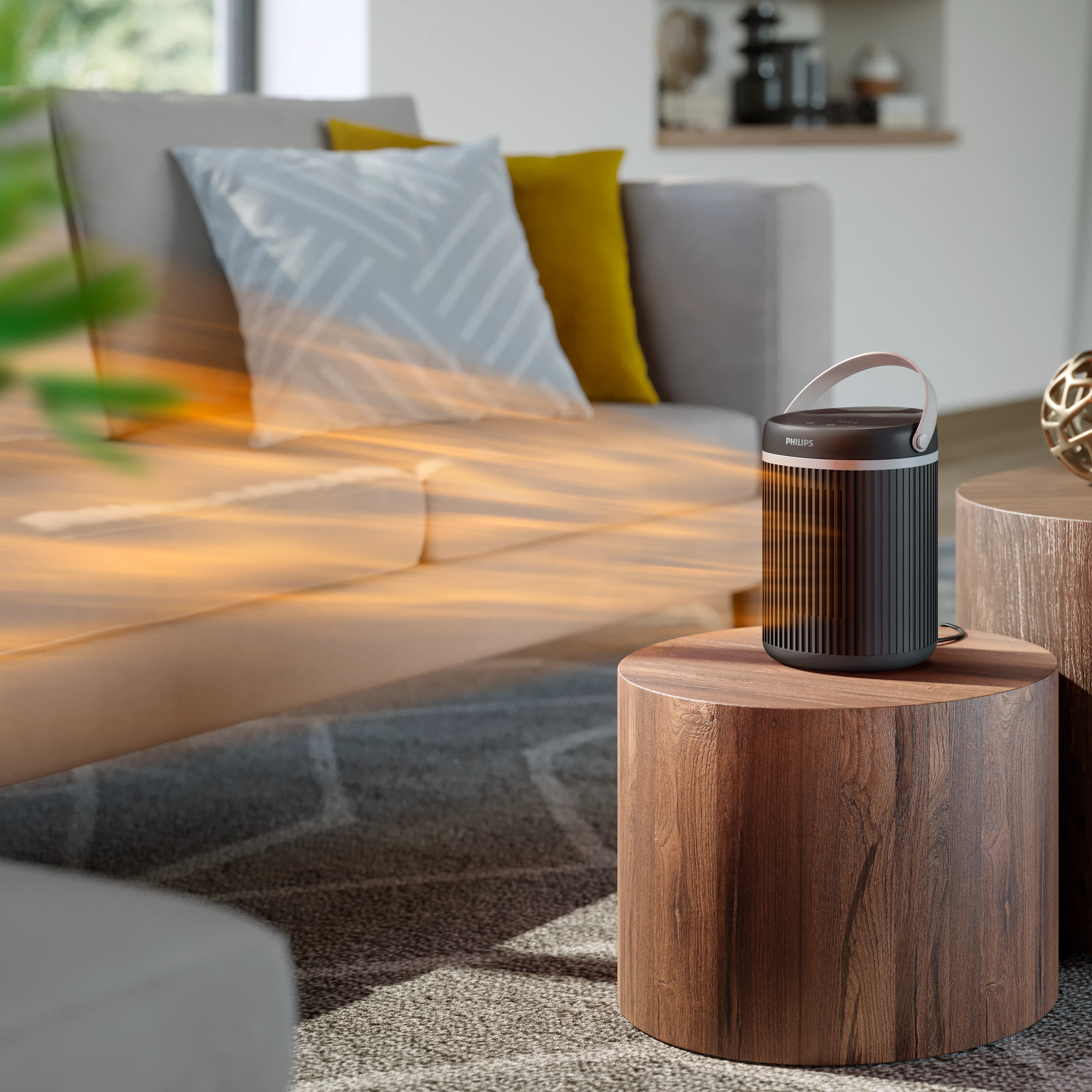 Purificatore d'aria Philips su tavolo in legno vicino a divano, con luce solare e tappeto.