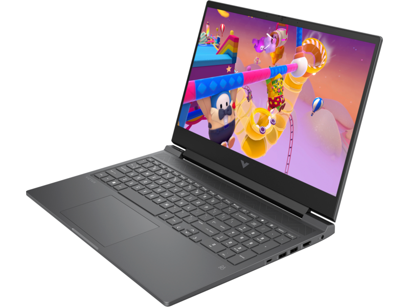 Szürke laptop nyitva, egy játékot mutatva a képernyőn, a billentyűzet látható. A laptop szögben van.