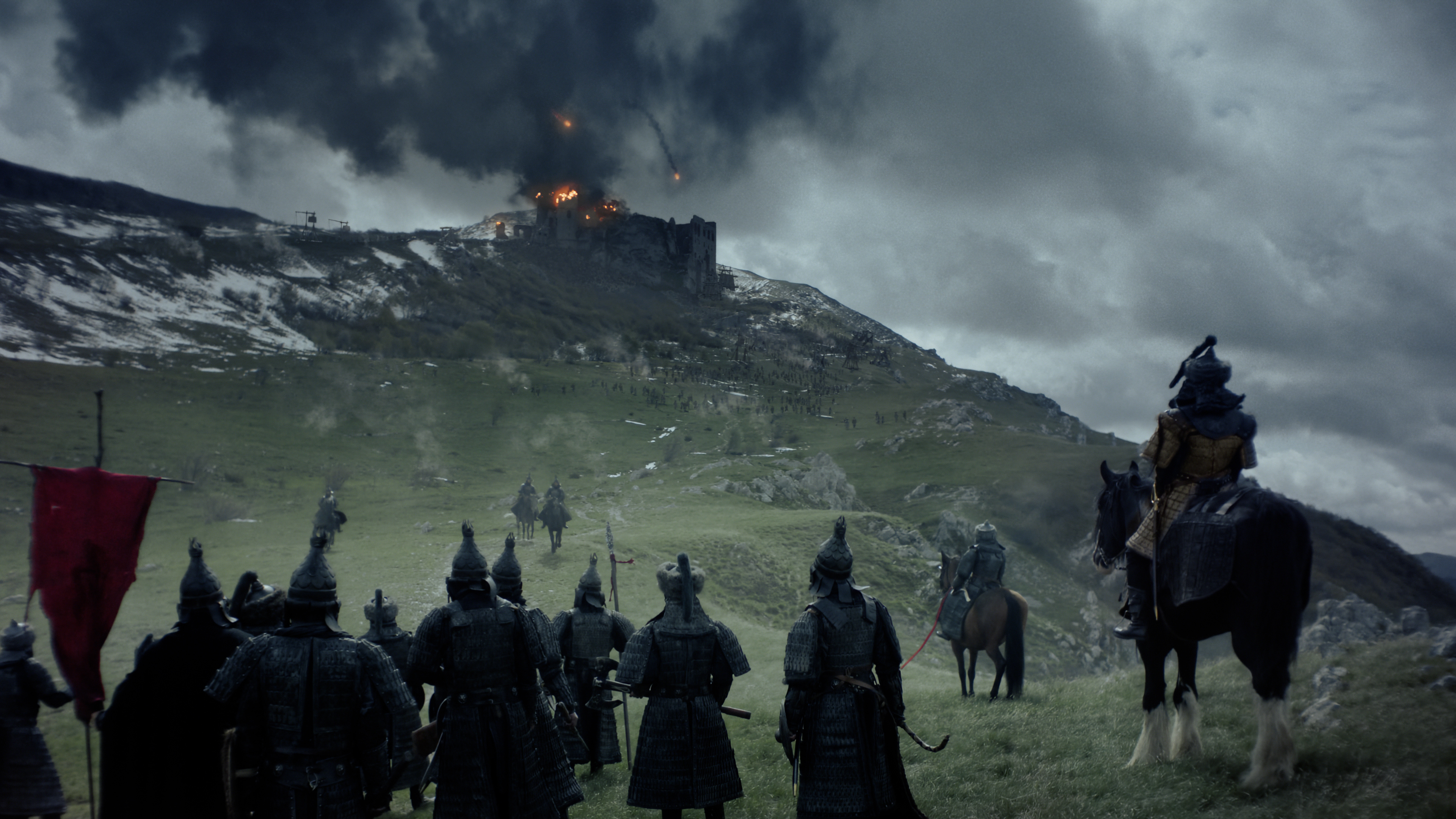 Eine dramatische Szene einer Schlacht mit Soldaten auf Pferden und einer brennenden Burg.