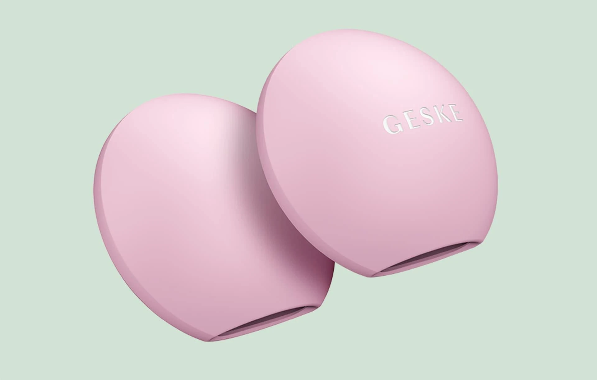 Un dispositivo de limpieza facial rosa, de forma ovalada, con el nombre GESKE.