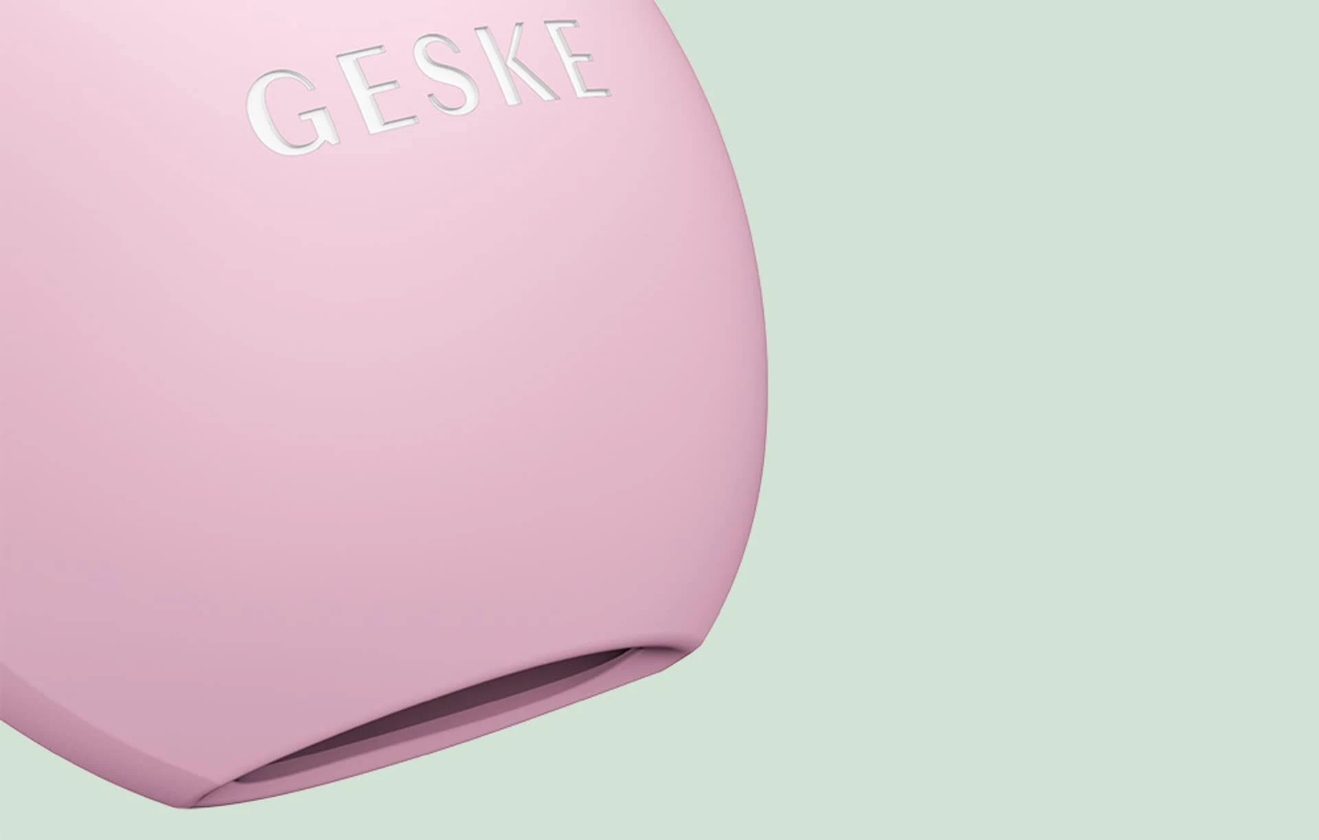 Masajeador facial GESKE rosa. Fondo claro.