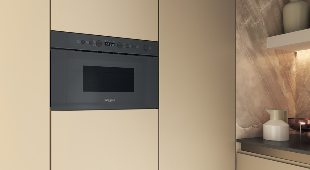 Beépített mikrohullámú sütő konyhaszekrényben, Whirlpool logóval.