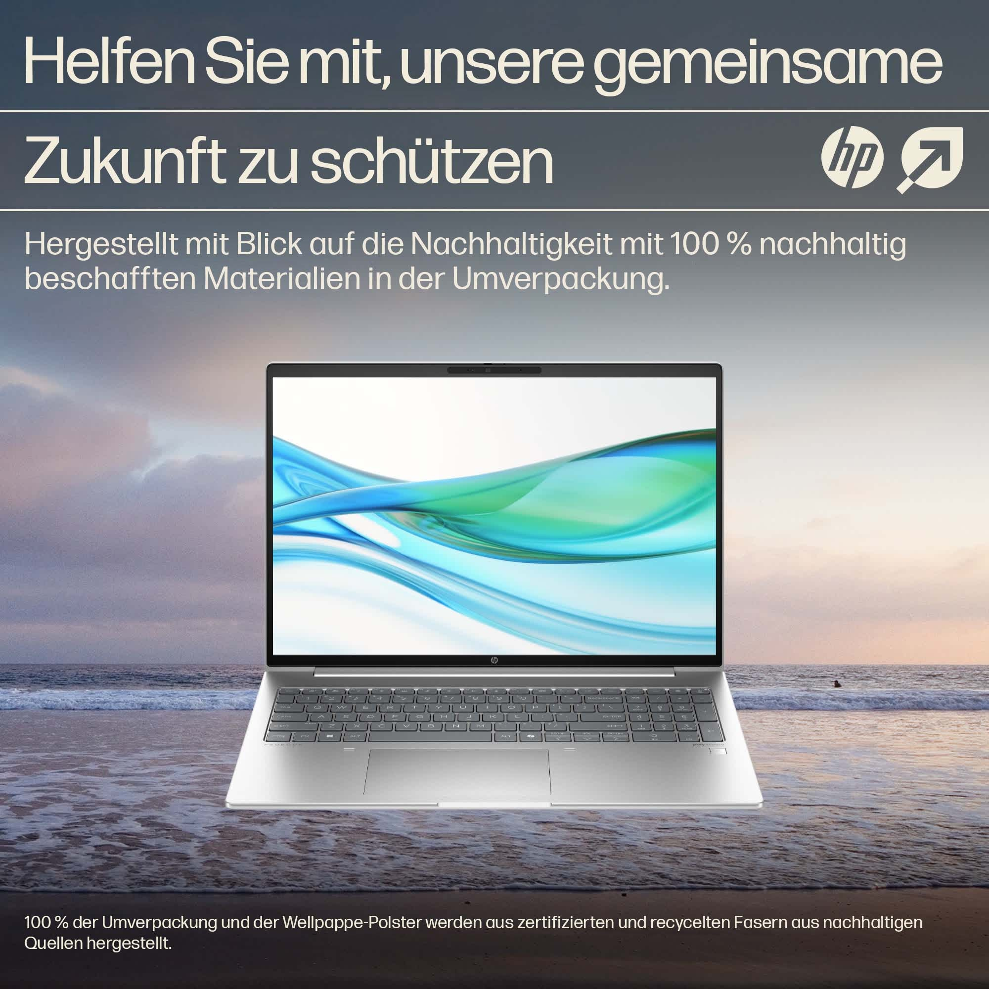 Laptop geöffnet, am Strand, Bildschirm zeigt eine Naturszene.