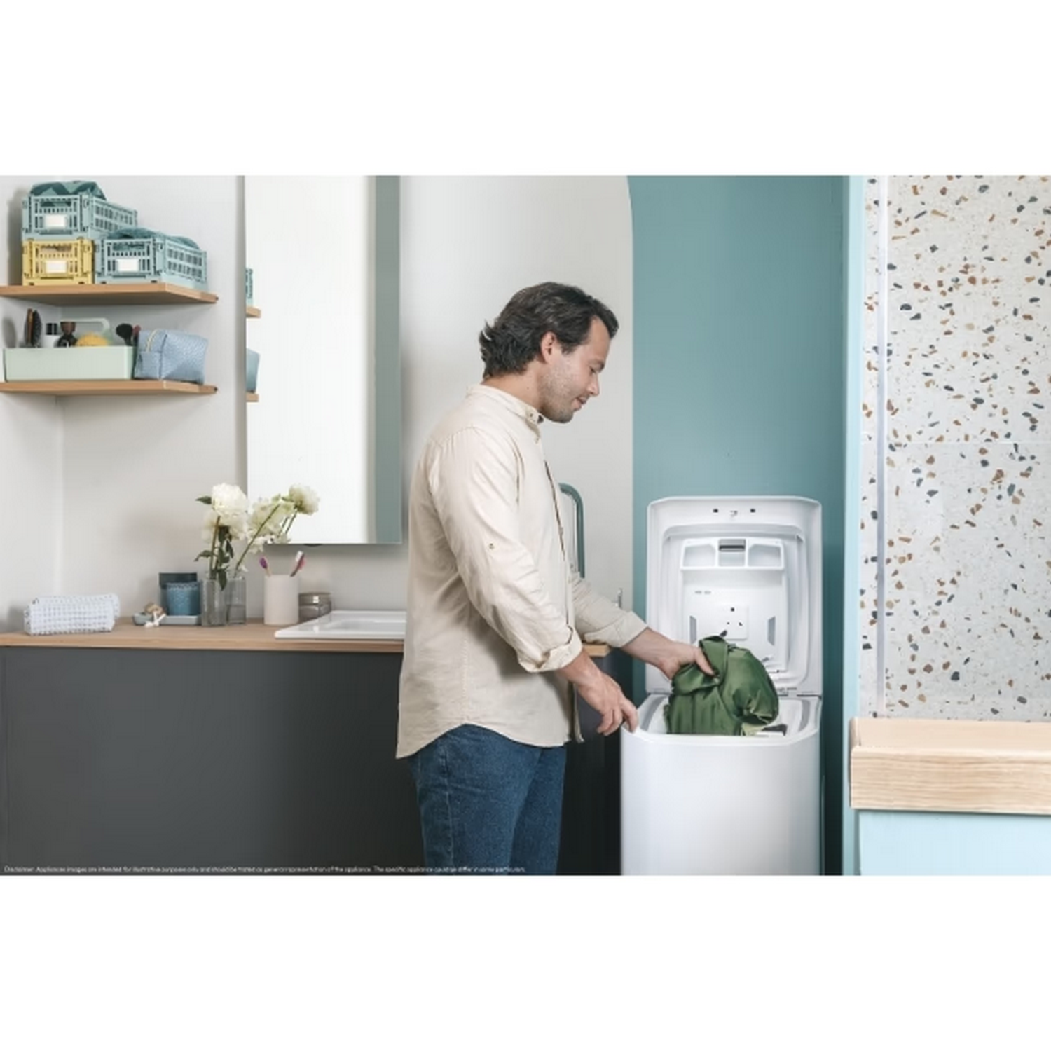 Hombre metiendo ropa en lavadora blanca de carga superior. Ambiente de baño.