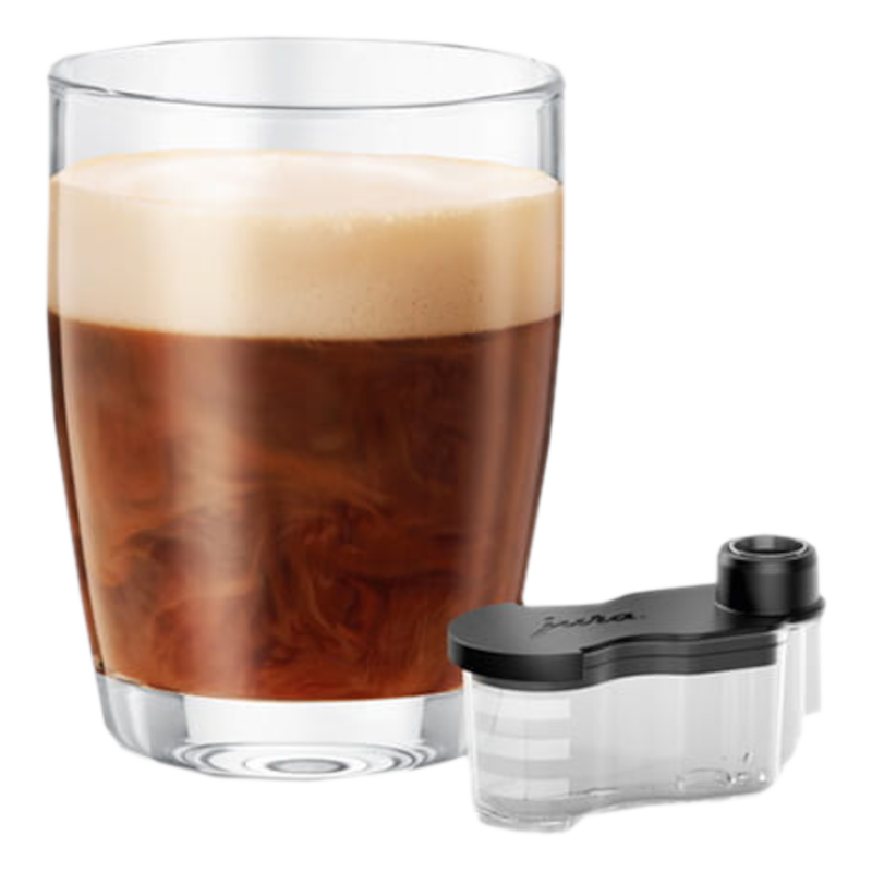 Un bicchiere di caffè con schiuma di latte e un piccolo contenitore accanto.