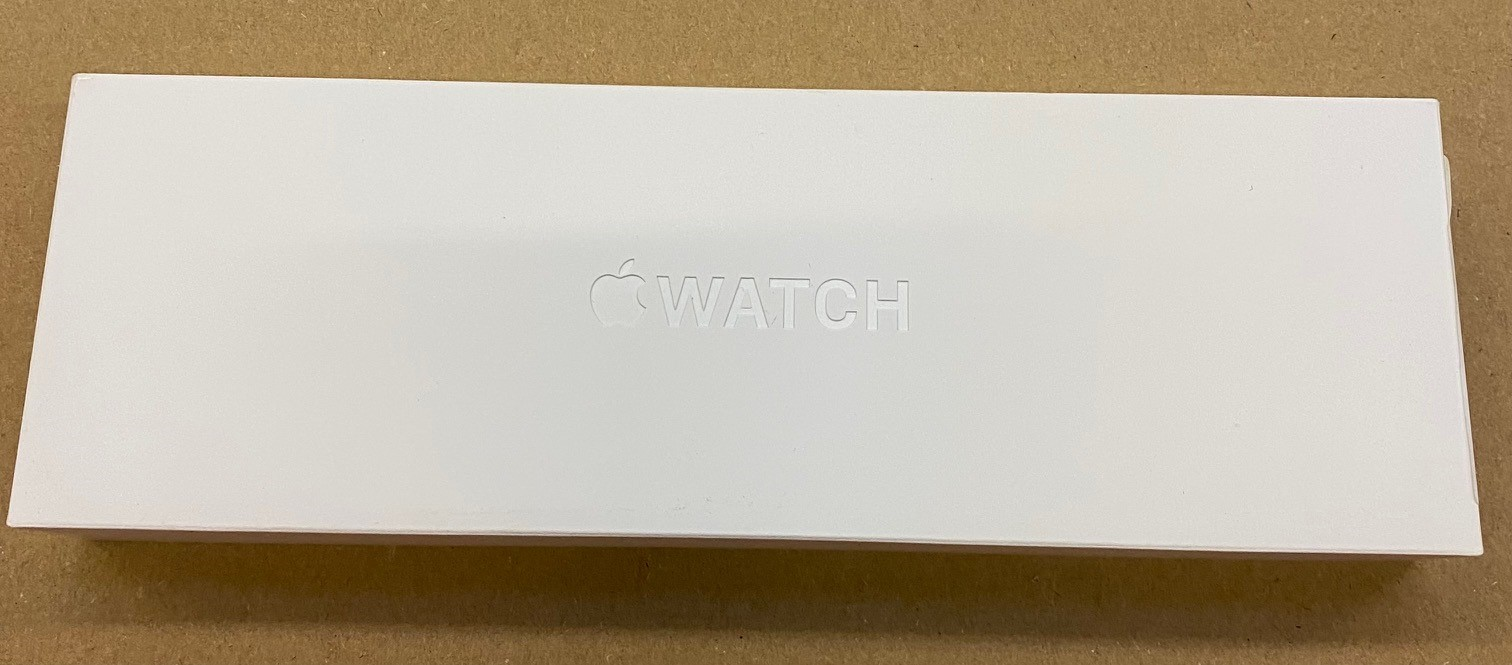 Białe pudełko Apple Watch z wytłoczonym logo i napisem.
