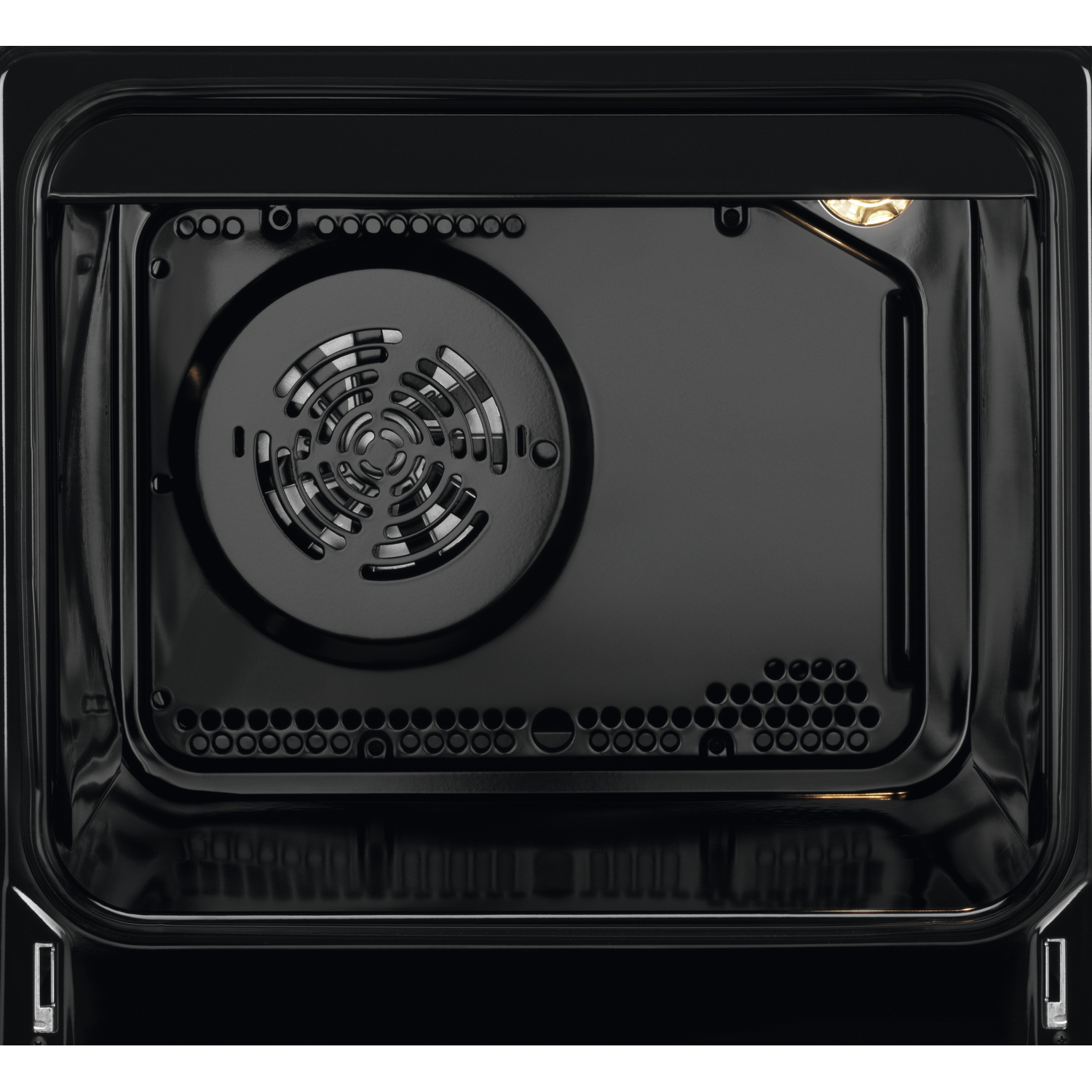 Inside of a black oven. The oven has a fan and lights. There are vent holes.