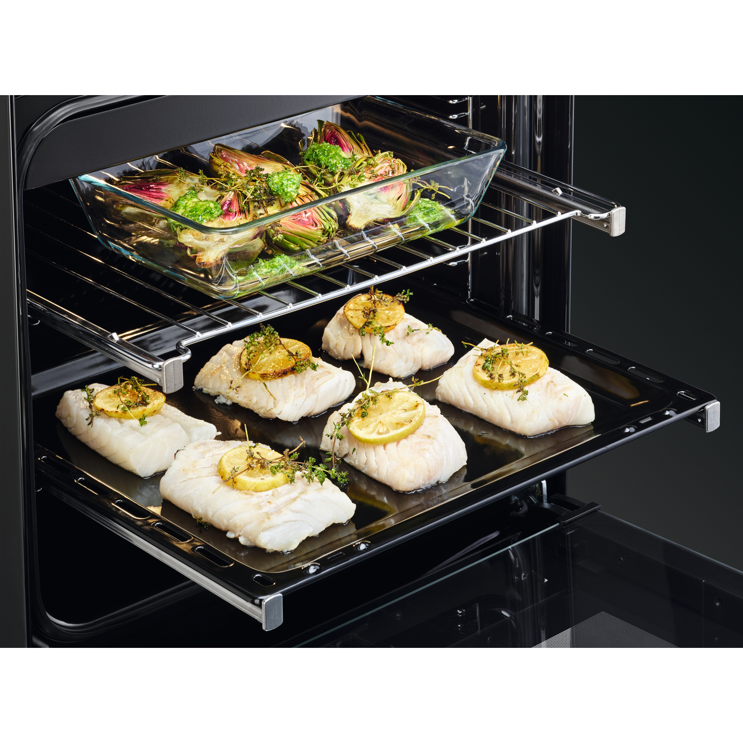 Oven interior with two racks, one with artichokes and one with fish. Black exterior.