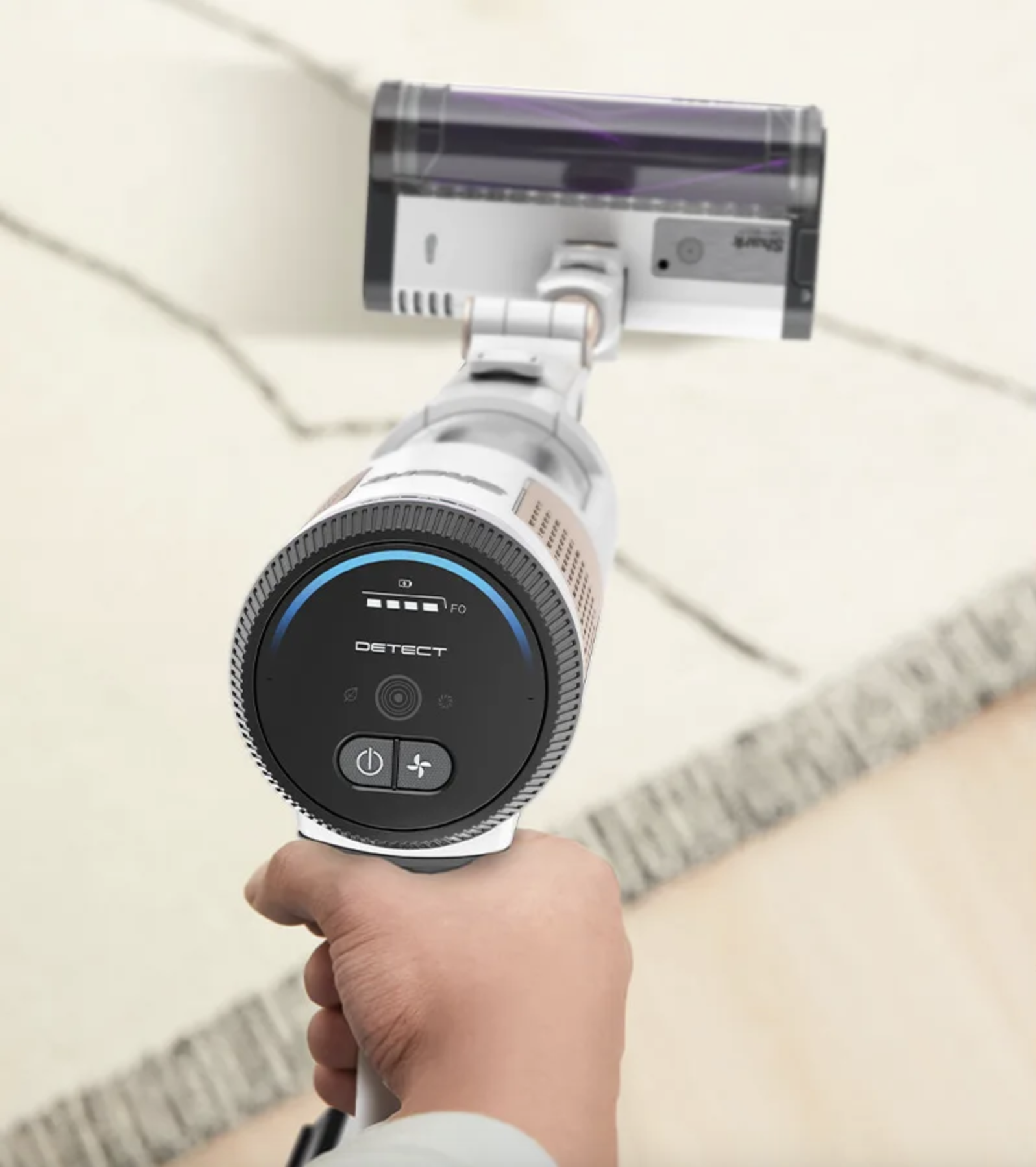Une personne tenant un aspirateur à main.