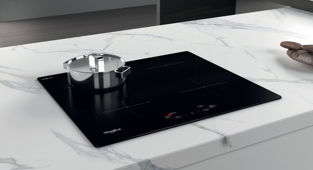Fekete Whirlpool indukciós főzőlap ezüst edénnyel egy fehér munkalapon.
