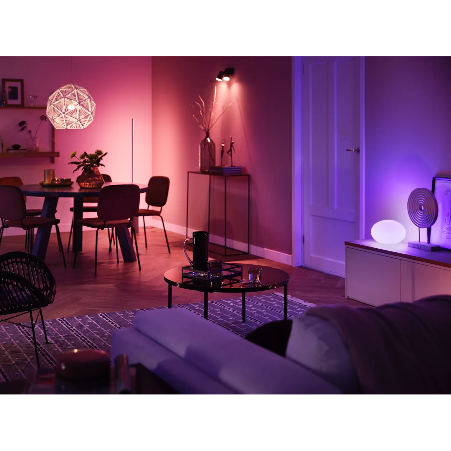 Living room with colored lights. Table, chairs, and decor are visible in the scene.