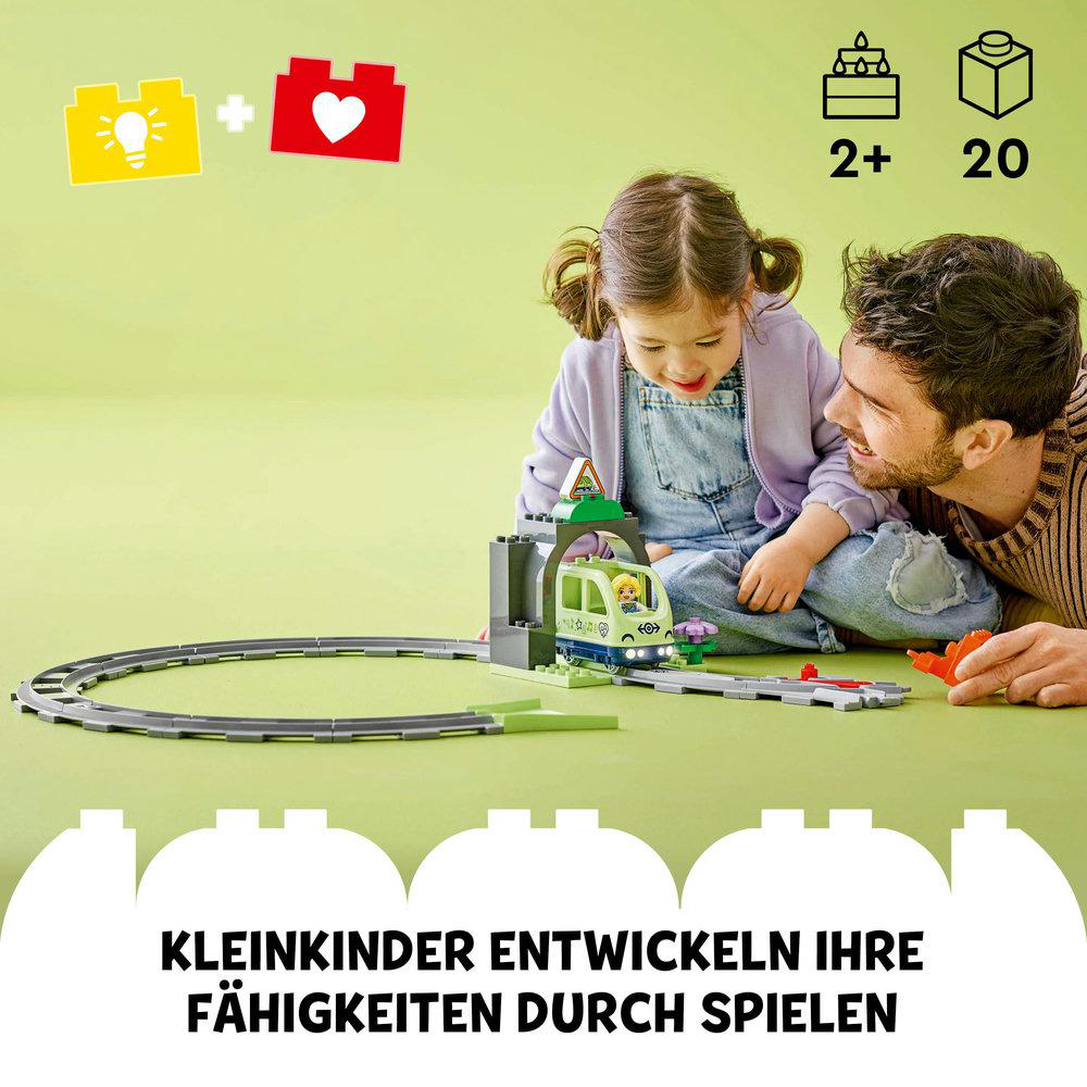 Ein Vater und seine Tochter spielen mit einer Spielzeugeisenbahn, mit Text über spielerisches Lernen.