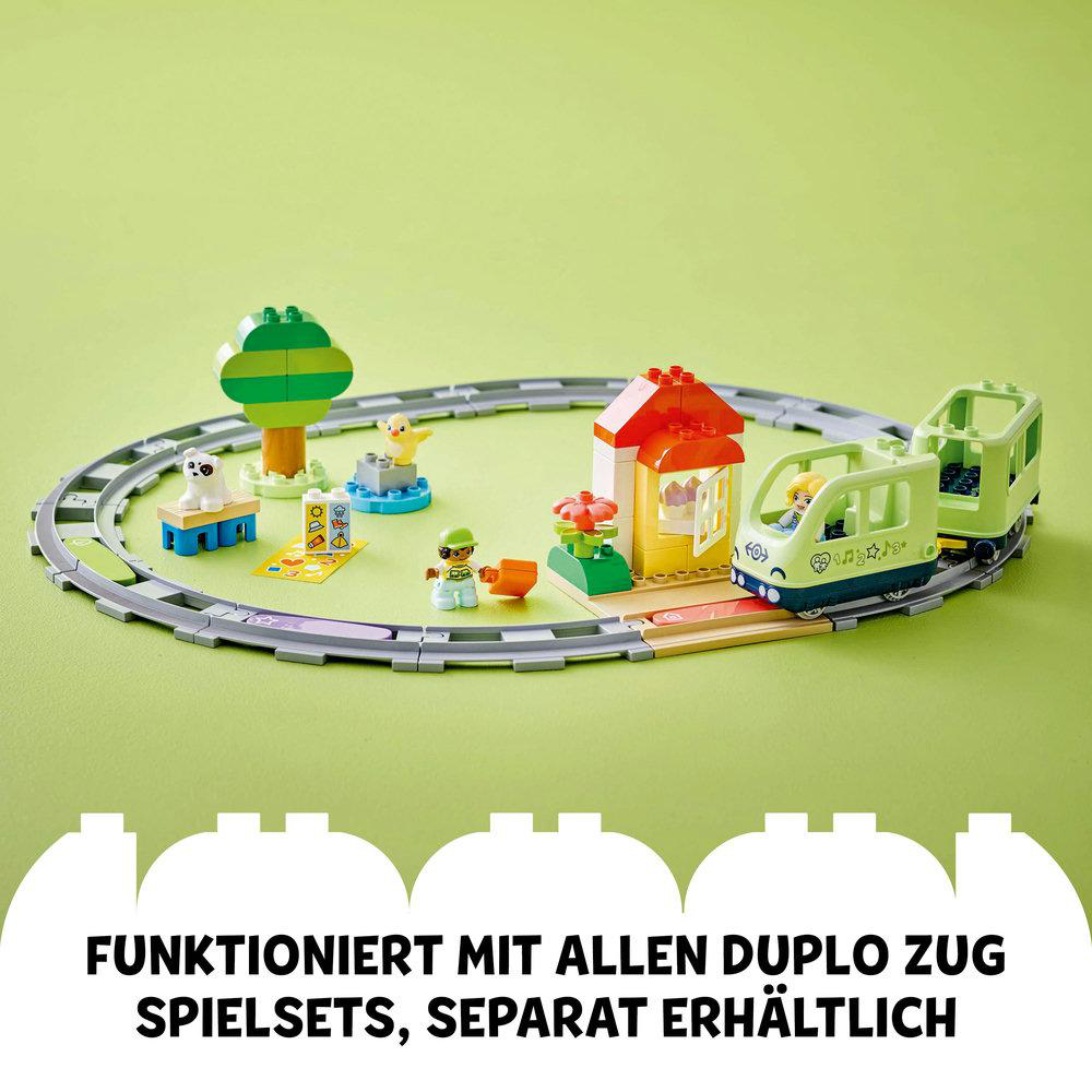 Lego Duplo Zug-Set mit bunten Elementen auf Grün.