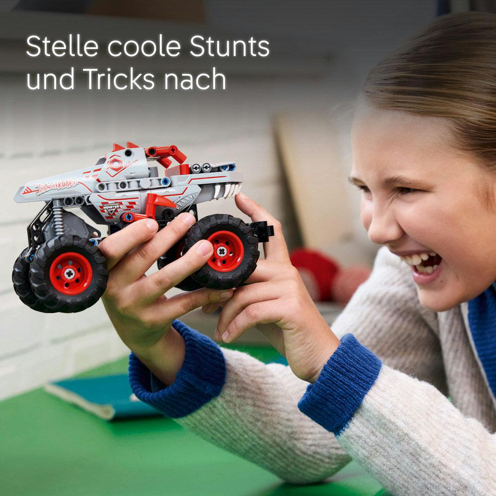 Mädchen spielt mit einem Lego Technic Monstertruck-Spielzeug.