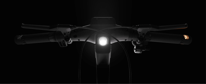 Vue aérienne d'un guidon de vélo avec un phare et des clignotants intégrés.