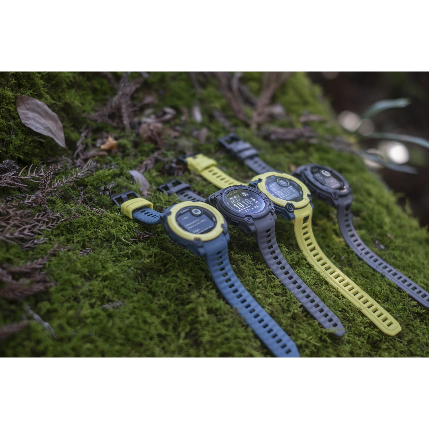 Horloges met gekleurde bandjes op groen mos.