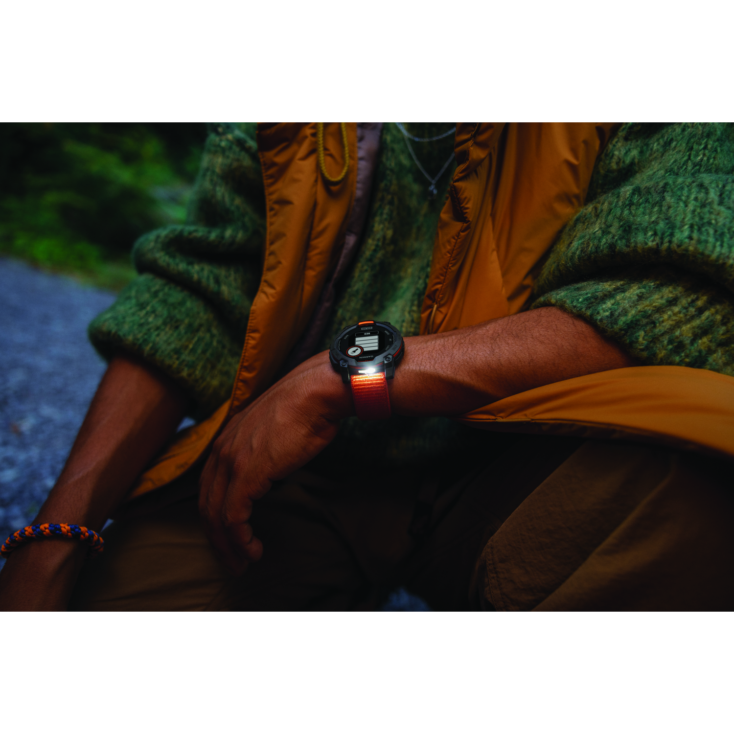 Person wearing smartwatch, showing time, in front of blurred green backdrop.
