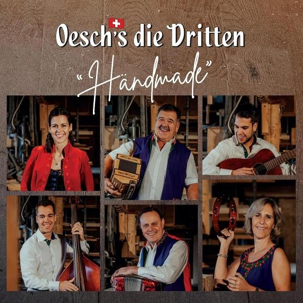 Albumcover: Sechs Personen in Quadraten. Rot, weiß, blau und grün. Brauner Hintergrund.