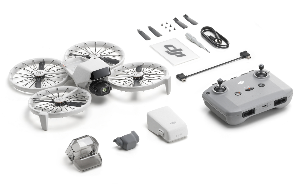 Dron i akcesoria ułożone na białej powierzchni. Zawiera drona, kontroler i baterię.