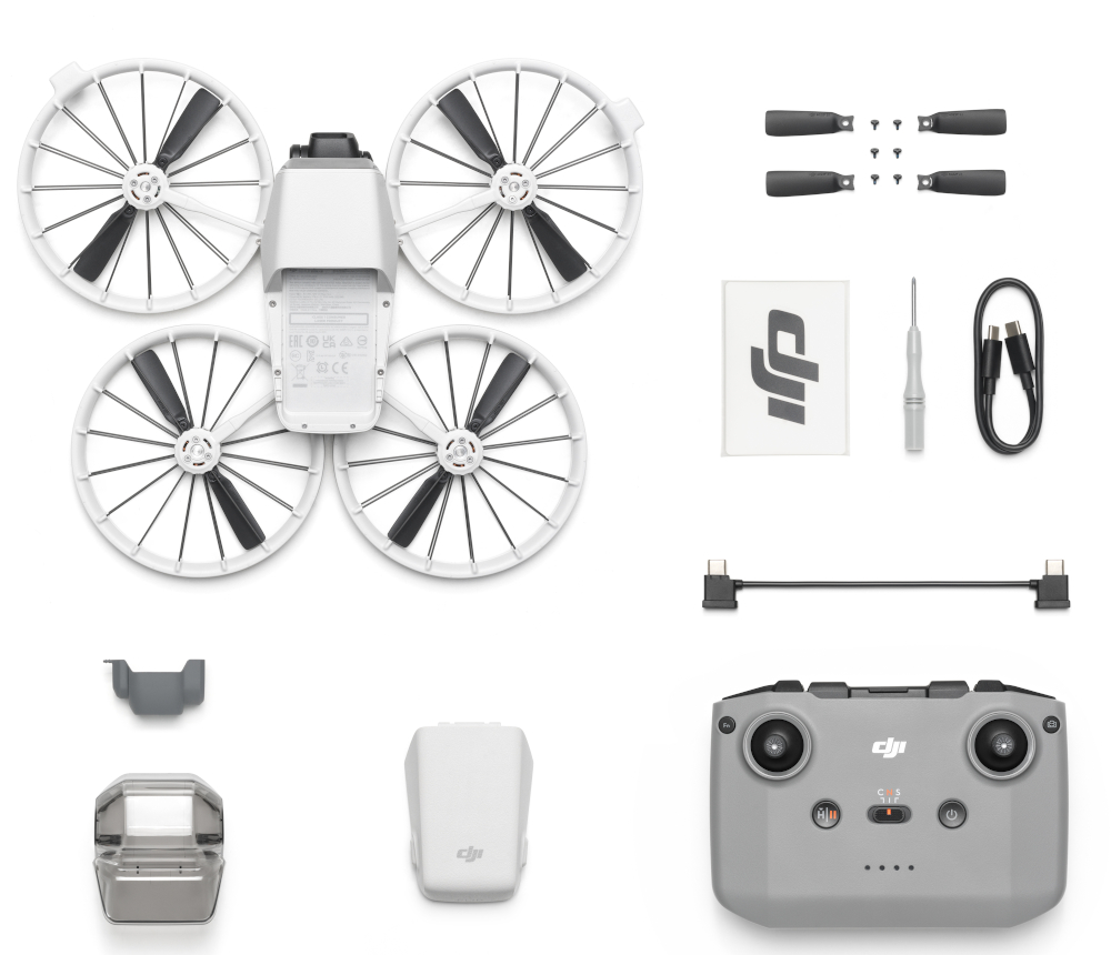 Części i akcesoria drona ułożone na białej powierzchni, z szarym kontrolerem.