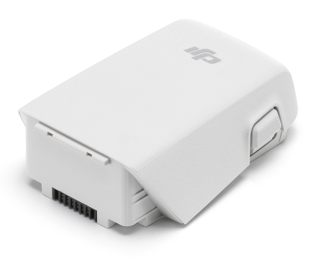 Biała bateria drona z logo i przyciskiem. Widoczne złącze. Na białej powierzchni.