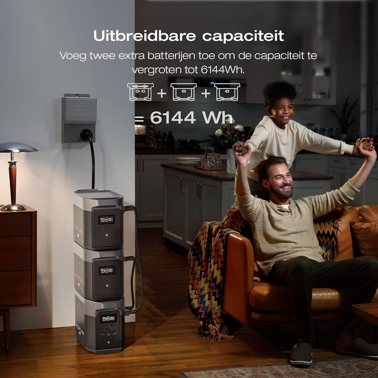Een man en een kind zijn blij naast drie gestapelde powerstations. Er is een lamp en een bank.