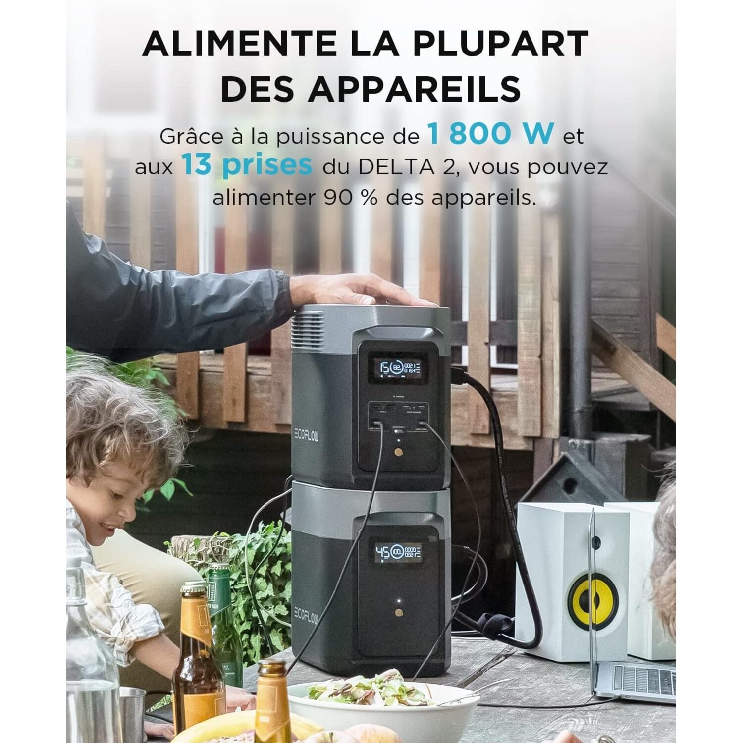 Un homme, un enfant et une femme sont près d'une table avec de la nourriture et une centrale électrique.