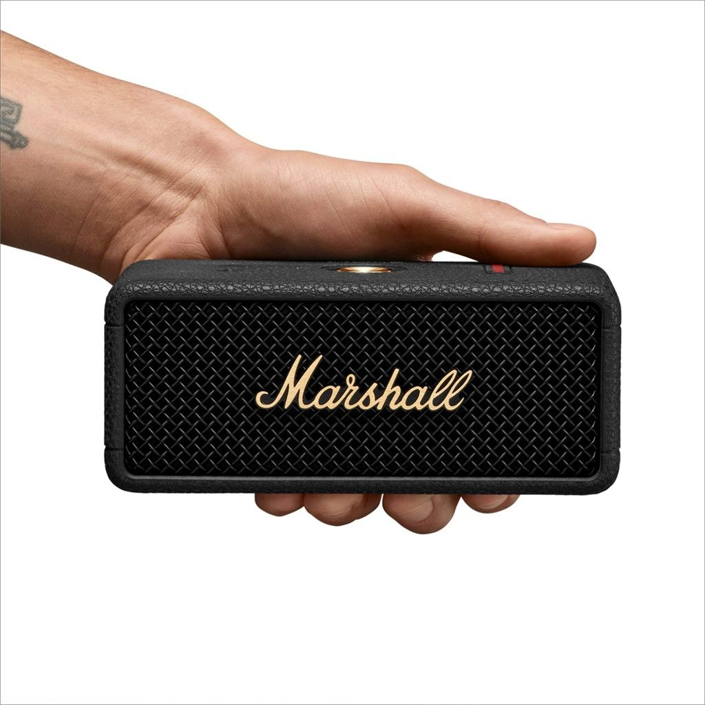 Hand hält einen schwarzen Marshall-Lautsprecher mit goldenem Marshall-Text.