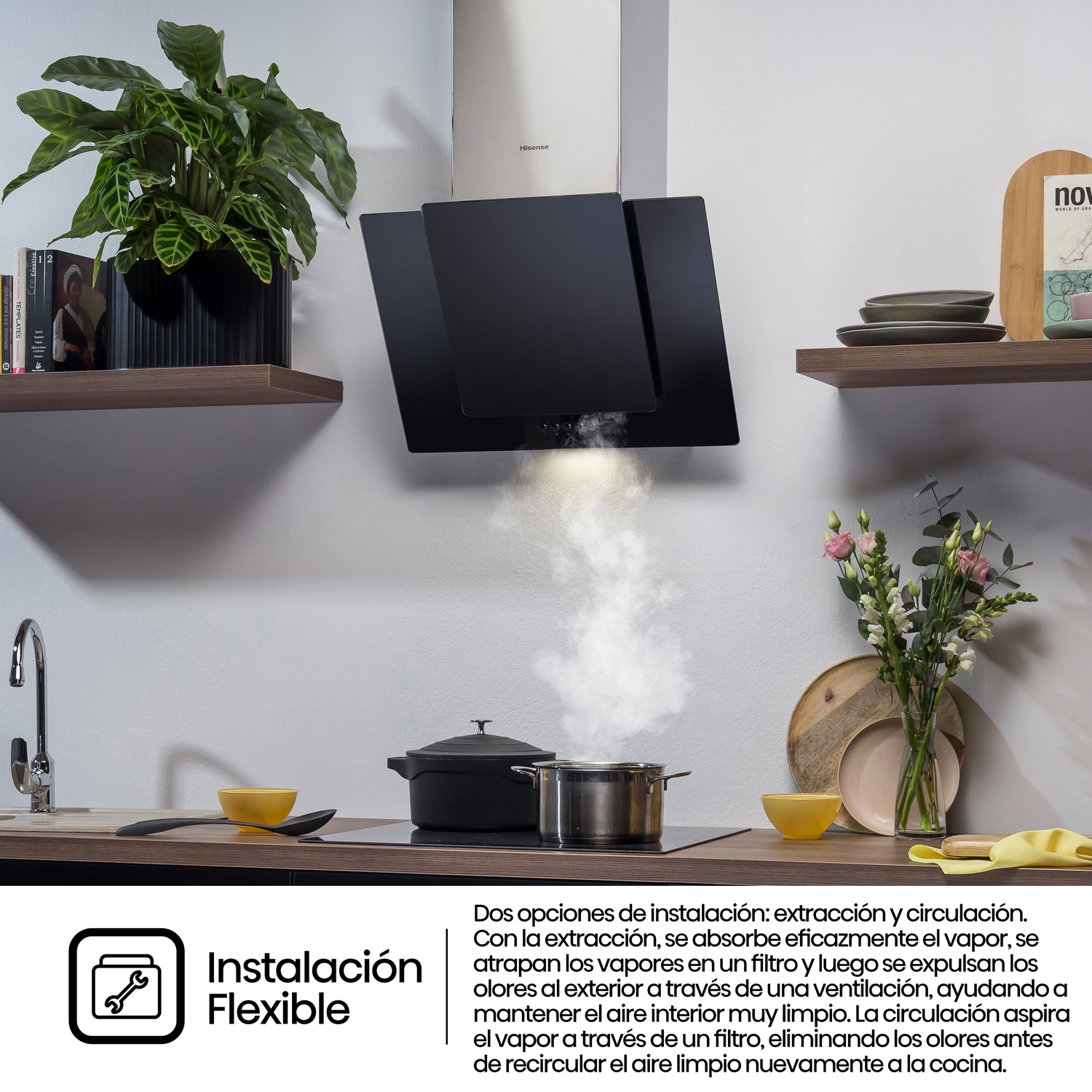 Escena de cocina con una campana extractora negra sobre una estufa con vapor y cocinando.