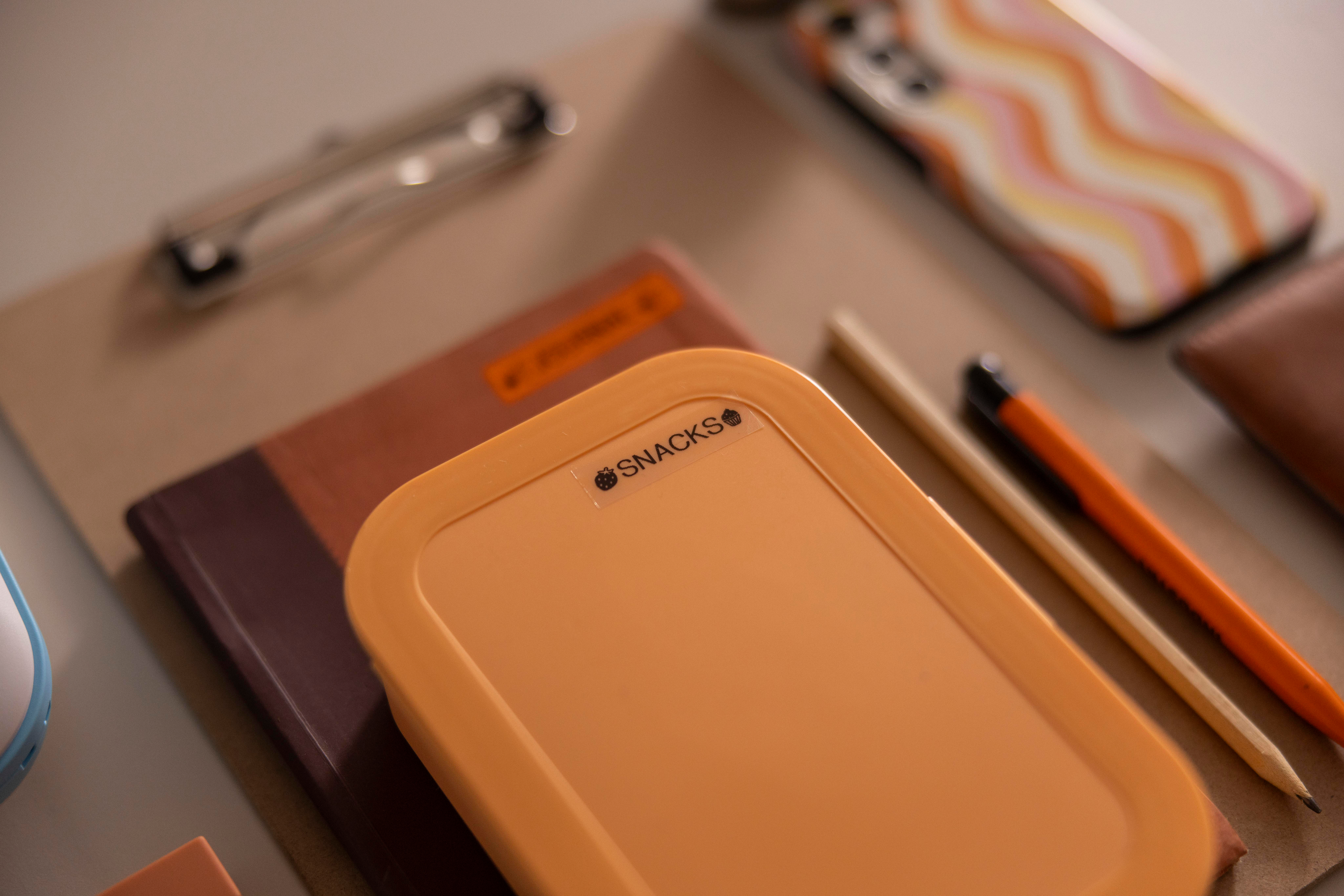 Brotdose, Notizbuch, Bleistifte und Telefon.