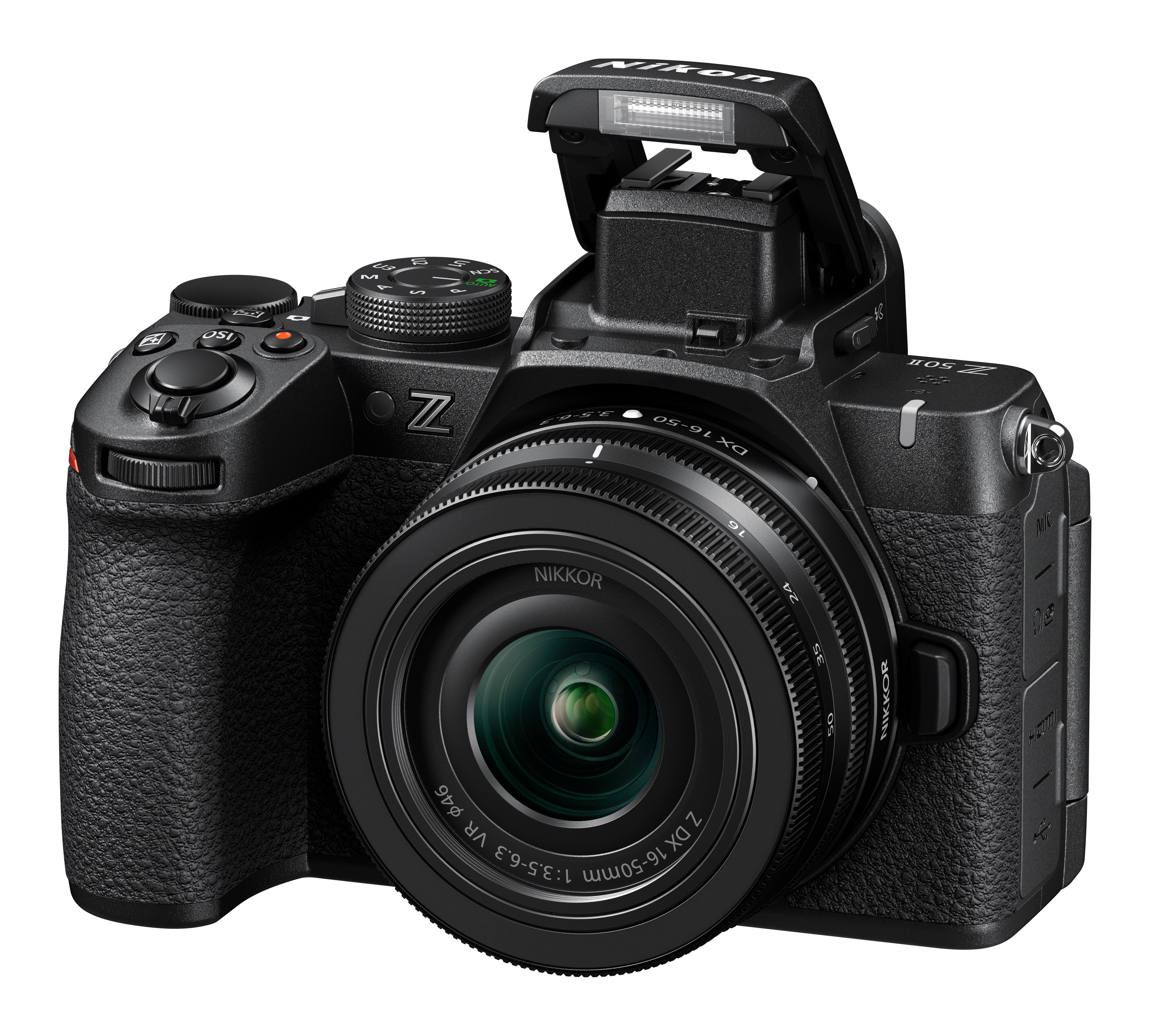 Schwarze Nikon Kamera mit Objektiv, Blitz offen, vor weißem Hintergrund.