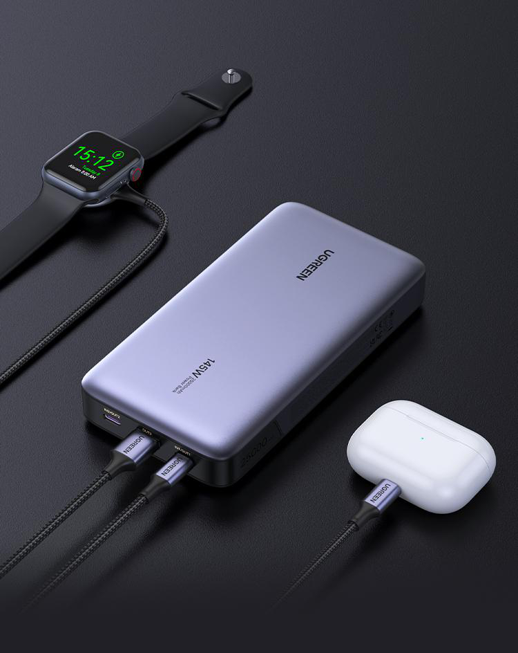 Eine Powerbank lädt eine Apple Watch und AirPods. Kabel verbinden Geräte mit der UGREEN Powerbank.