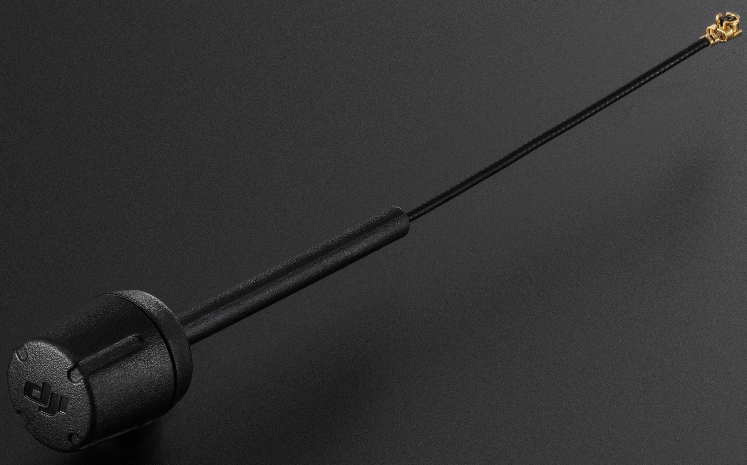Schwarze Antenne mit Metallanschluss. Sie hat ein schwarzes Kabel und einen schwarzen Fuß.