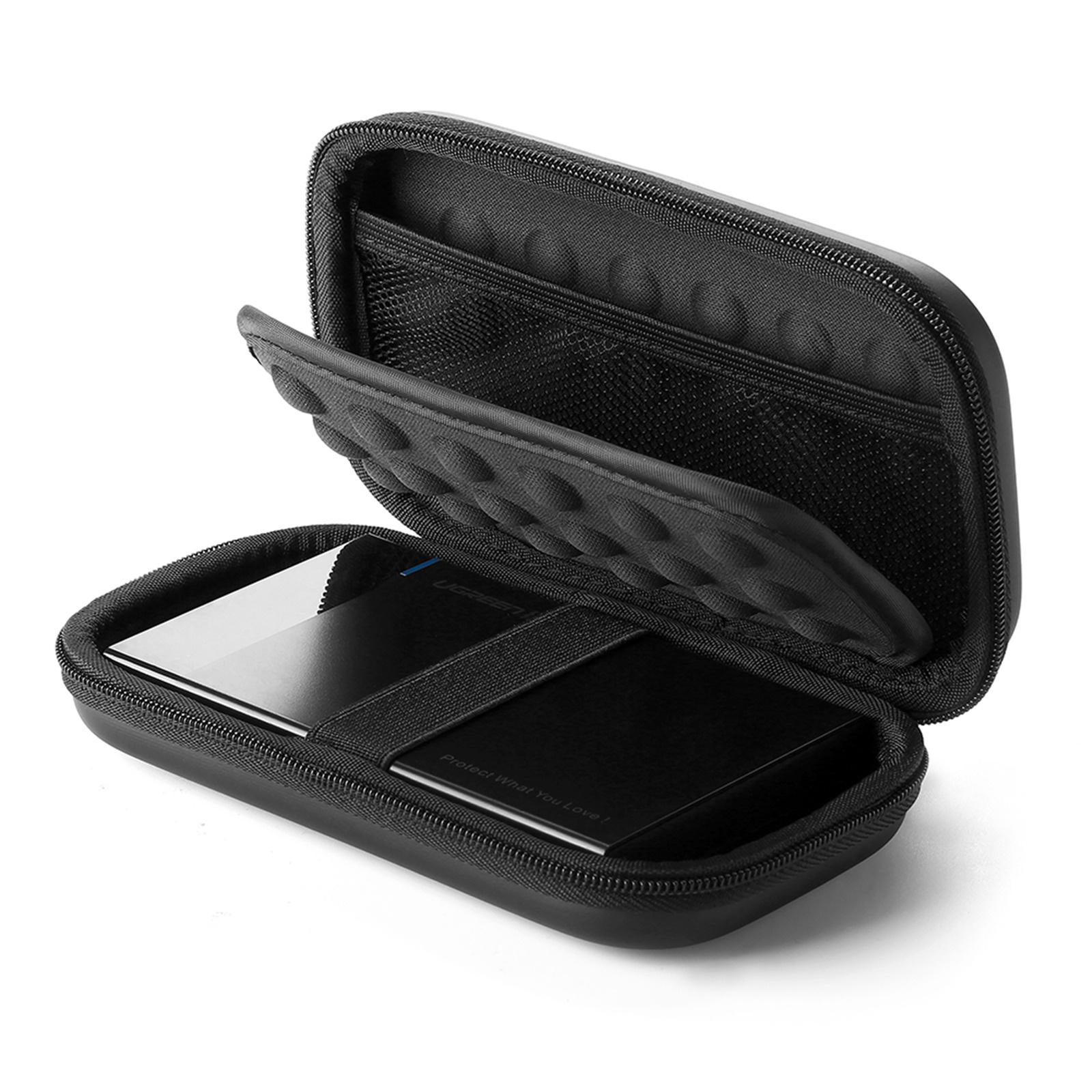 Ein schwarzes UGREEN-Etui ist geöffnet und zeigt eine Festplatte und einen elastischen Gurt auf weißem Grund.